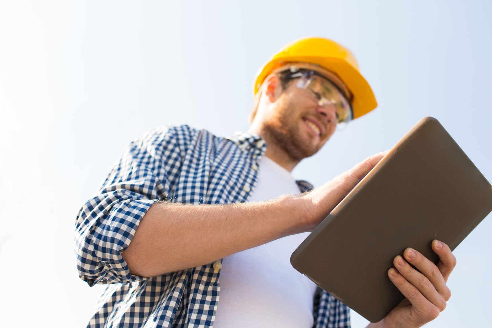 Contractor in a work shirt standing in front of a house